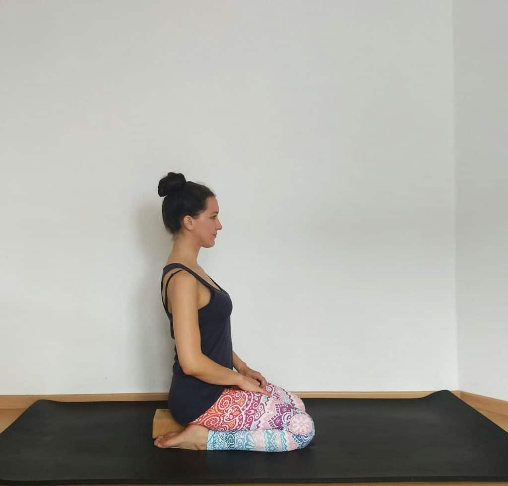 image of a women sitting in hero pose to stretch internal hip rotators